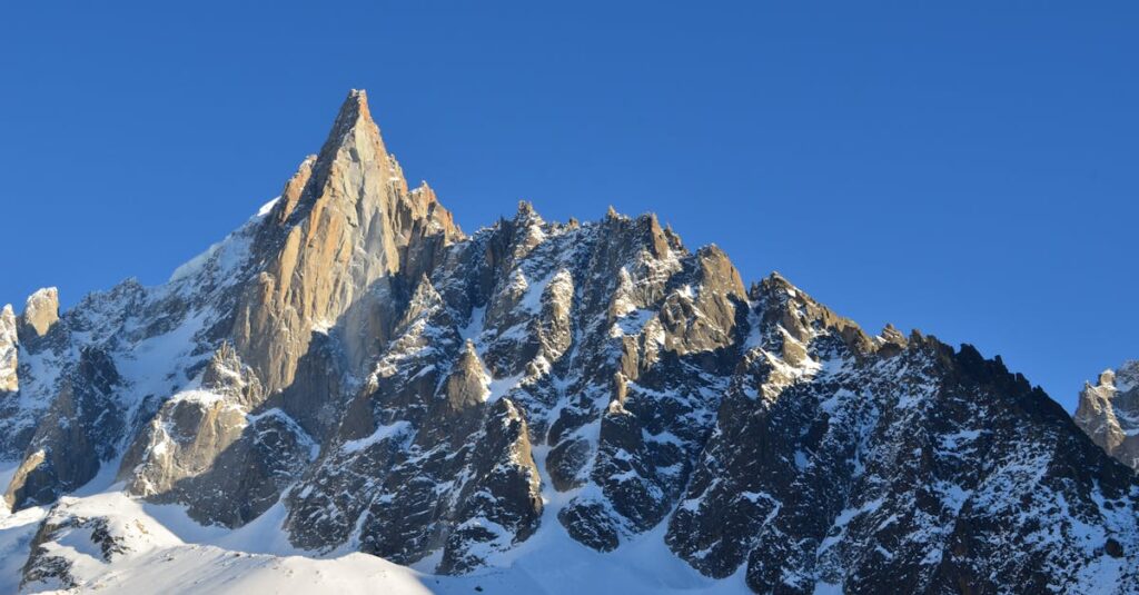 Majestic snowy peaks of Aiguille du Dru under clear blue skies in Chamonix, France.